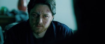 Movie still from “Filth” (2013), directed by Jon S. Baird – A person wearing a black shirt; Close Up shot, Over the shoulder angle
