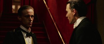 Movie still from “Finding Neverland” (2004), directed by Marc Forster – Two men in suits are standing next to each other; Close Up shot, Over the shoulder angle