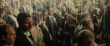 Movie still from “Finding Neverland” (2004), directed by Marc Forster – A group of people sitting in a room under rain; Wide shot, High angle