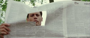 Movie still from “Finding Neverland” (2004), directed by Marc Forster – A man looking through a sheet of newspaper; Close Up shot, Low angle