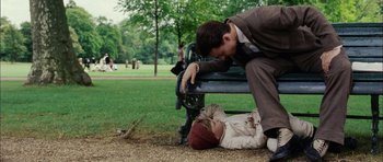 Movie still from “Finding Neverland” (2004), directed by Marc Forster – A man kneeling down next to a child laying on the ground in a park; Wide shot, High angle