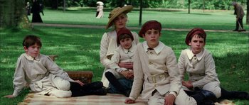 Movie still from “Finding Neverland” (2004), directed by Marc Forster – A woman and two children sitting on a blanket in a park; Wide shot, High angle