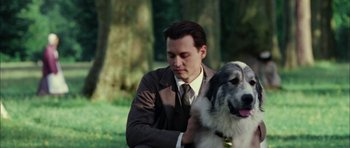 Movie still from “Finding Neverland” (2004), directed by Marc Forster – A man in a suit and tie petting a dog; Close Up shot, Low angle