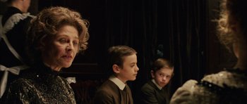 Movie still from “Finding Neverland” (2004), directed by Marc Forster – A group of people sitting next to each other in a room; Close Up shot, Over the shoulder angle