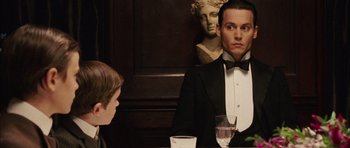 Movie still from “Finding Neverland” (2004), directed by Marc Forster – A man in a tuxedo sitting at a table with a boy; Close Up shot, Over the shoulder angle