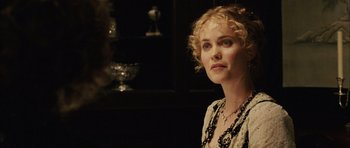 Movie still from “Finding Neverland” (2004), directed by Marc Forster – A woman with blonde curly hair wearing a black and white dress; Close Up shot, Over the shoulder angle