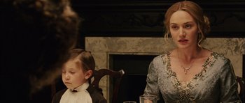 Movie still from “Finding Neverland” (2004), directed by Marc Forster – Two people sitting at a table with a glass of water; Medium shot, Over the shoulder angle