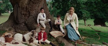 Movie still from “Finding Neverland” (2004), directed by Marc Forster – A group of people and a dog sitting under a tree; Wide shot, High angle