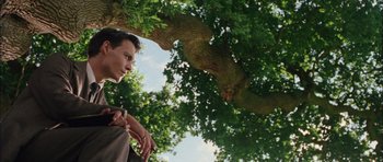 Movie still from “Finding Neverland” (2004), directed by Marc Forster – A man standing next to a tree looking up at the sky; Medium shot, Low angle