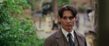 Movie still from “Finding Neverland” (2004), directed by Marc Forster – A man with long hair wearing a suit and tie; Close Up shot, Low angle