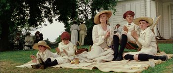 Movie still from “Finding Neverland” (2004), directed by Marc Forster – Two women and a man sitting on a blanket on the grass; Wide shot, High angle