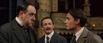 Movie still from “Finding Neverland” (2004), directed by Marc Forster – A group of men standing next to each other in a room; Medium shot, Low angle