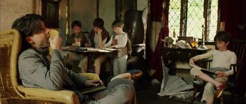 Movie still from “Finding Neverland” (2004), directed by Marc Forster – A group of young men sitting around a table; Medium shot, High angle