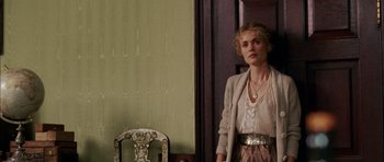 Movie still from “Finding Neverland” (2004), directed by Marc Forster – A woman standing in front of a chair in front of a door; Medium shot, Over the shoulder angle