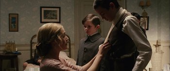 Movie still from “Finding Neverland” (2004), directed by Marc Forster – A woman helping a young boy put on a tie; Medium shot, Over the shoulder angle