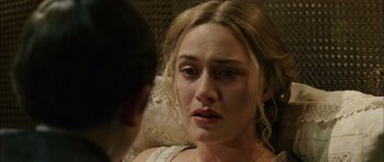 Movie still from “Finding Neverland” (2004), directed by Marc Forster – A person sitting down with her eyes wide open; Close Up shot, Over the shoulder angle