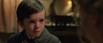 Movie still from “Finding Neverland” (2004), directed by Marc Forster – A young boy wearing a suit and tie looking at the camera; Close Up shot, Over the shoulder angle