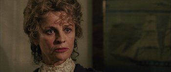 Movie still from “Finding Neverland” (2004), directed by Marc Forster – An older woman wearing a white shirt and a lace collar; Close Up shot, Over the shoulder angle