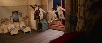 Movie still from “Finding Neverland” (2004), directed by Marc Forster – A group of people jumping in the air in front of a window; Wide shot, Overhead angle