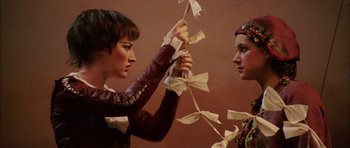 Movie still from “Finding Neverland” (2004), directed by Marc Forster – A woman holding a string of paper cranes in front of another woman's face; Close Up shot, Low angle