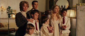 Movie still from “Finding Neverland” (2004), directed by Marc Forster – A group of people standing next to each other in front of a mirror; Medium shot, High angle