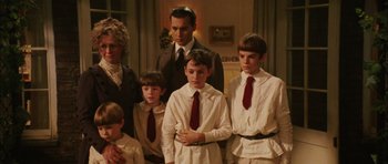 Movie still from “Finding Neverland” (2004), directed by Marc Forster – A group of people standing around each other in a room; Medium shot, High angle