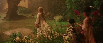 Movie still from “Finding Neverland” (2004), directed by Marc Forster – A woman in a white dress standing next to a man; Wide shot, High angle