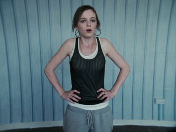 Movie still from “Fish Tank” (2009), directed by Andrea Arnold – A young woman standing in front of a blue wall; Medium shot, Low angle