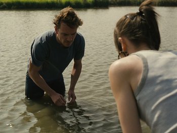 Movie still from “Fish Tank” (2009), directed by Andrea Arnold – A man and a woman wading in a body of water; Medium shot, High angle