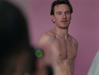 Movie still from “Fish Tank” (2009), directed by Andrea Arnold – A man is taking a picture of himself in the mirror; Medium shot, Low angle
