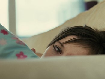 Movie still from “Fish Tank” (2009), directed by Andrea Arnold – A person laying in a bed; Close Up shot, High angle