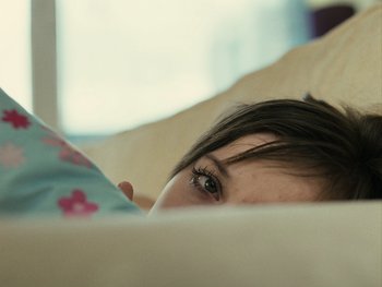 Movie still from “Fish Tank” (2009), directed by Andrea Arnold – A person laying in a bed; Close Up shot, High angle