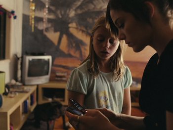 Movie still from “Fish Tank” (2009), directed by Andrea Arnold – A girl and a woman looking at a cell phone; Medium shot, High angle