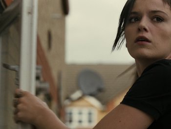 Movie still from “Fish Tank” (2009), directed by Andrea Arnold – A woman in a black shirt is looking at the camera; Close Up shot, Low angle