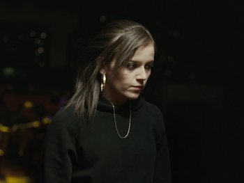 Movie still from “Fish Tank” (2009), directed by Andrea Arnold – A woman in a black shirt is looking at the camera; Close Up shot, High angle