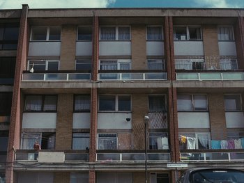 Movie still from “Fish Tank” (2009), directed by Andrea Arnold – An apartment building with many balconies on the outside; Extreme Wide shot, Low angle
