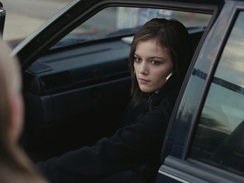Movie still from “Fish Tank” (2009), directed by Andrea Arnold – A woman sitting in the drivers seat of a car; Close Up shot, Over the shoulder angle