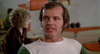 Movie still from “Five Easy Pieces” (1970), directed by Bob Rafelson – A person wearing a white t - shirt; Close Up shot, Over the shoulder angle