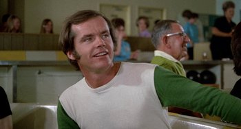 Movie still from “Five Easy Pieces” (1970), directed by Bob Rafelson – A person sitting in front of a group of people; Close Up shot, Over the shoulder angle