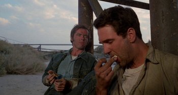 Movie still from “Five Easy Pieces” (1970), directed by Bob Rafelson – Two men sitting next to each other eating food; Medium shot, Low angle