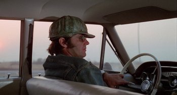 Movie still from “Five Easy Pieces” (1970), directed by Bob Rafelson – A man wearing a hat sitting in the driver's seat of a car; Medium shot, Low angle