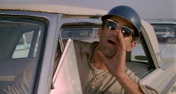 Movie still from “Five Easy Pieces” (1970), directed by Bob Rafelson – A man wearing a hard hat while driving a car; Close Up shot, Low angle