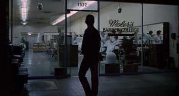 Movie still from “Five Easy Pieces” (1970), directed by Bob Rafelson – A man walking in front of a barber shop; Wide shot, Low angle