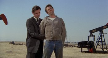 Movie still from “Five Easy Pieces” (1970), directed by Bob Rafelson – Two men standing next to each other on a beach; Medium shot, Low angle