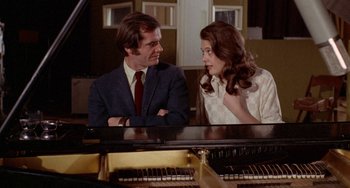 Movie still from “Five Easy Pieces” (1970), directed by Bob Rafelson – A man and a woman sitting next to a piano; Medium shot, High angle