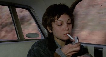 Movie still from “Five Easy Pieces” (1970), directed by Bob Rafelson – A woman smoking a cigarette while sitting in a car; Close Up shot, High angle