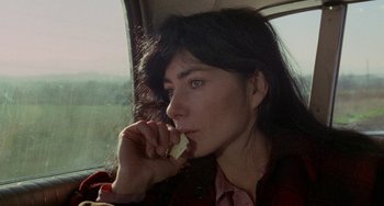 Movie still from “Five Easy Pieces” (1970), directed by Bob Rafelson – A woman sitting in a car eating a piece of food; Close Up shot, High angle