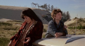 Movie still from “Five Easy Pieces” (1970), directed by Bob Rafelson – Two people sitting on a car in the desert; Medium shot, High angle