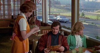 Movie still from “Five Easy Pieces” (1970), directed by Bob Rafelson – A man sitting at a table in front of two women; Medium shot, Over the shoulder angle