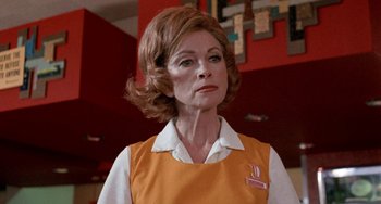 Movie still from “Five Easy Pieces” (1970), directed by Bob Rafelson – An older woman in an orange shirt is looking at the camera; Close Up shot, Low angle